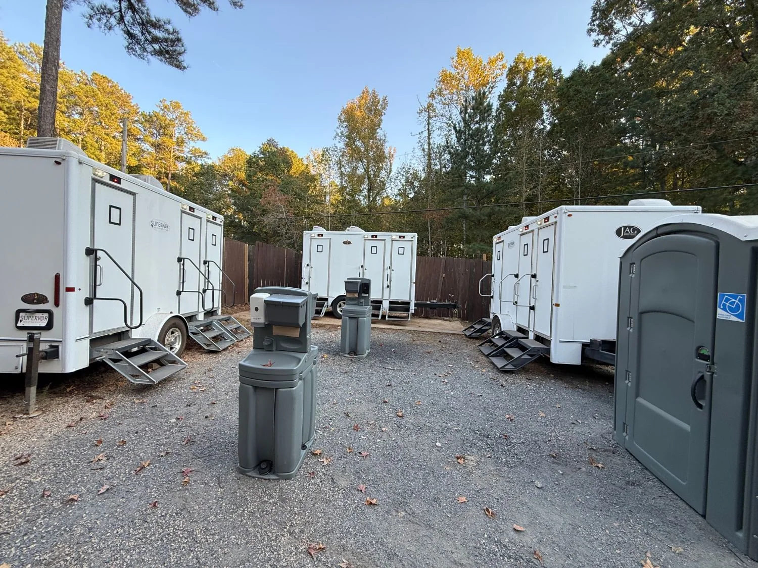 Superior Location Solutions restroom trailers with portable handwashing stations and an accessible portable toilet in a gravel privy area at the Georgia Renaissance Festival